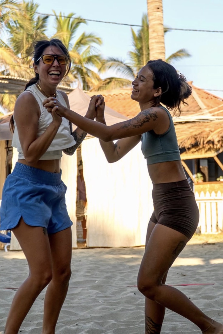 Two players laughing together on the sand