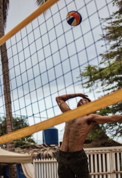 A player swinging at the ball above the net in Mancora