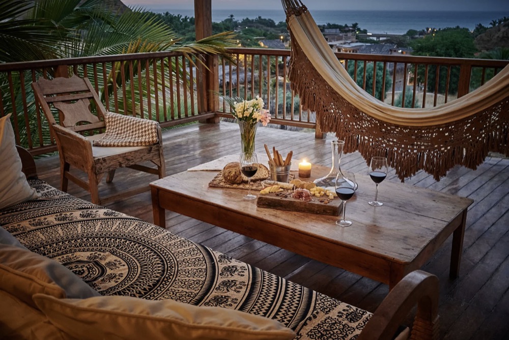 A terrace at Villa del Sol at dusk, with a hammock and the coast beyond